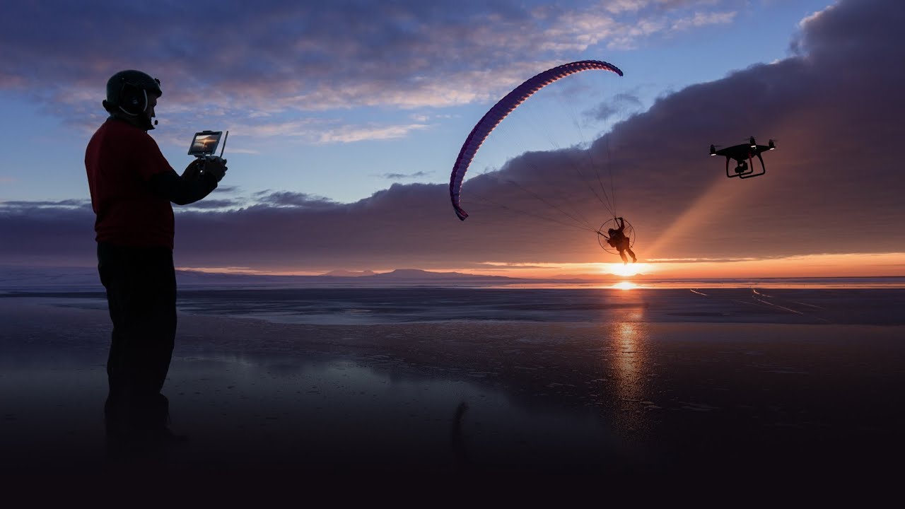 человек с пультом управления дроном смотрит в небо на закате, вид со спины, профессиональная фотосъемка человек с пультом управления дроном смотрит в небо на закате, вид со спины, профессиональная фотосъемка
